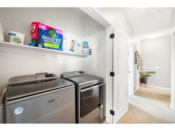 a utility room with fridge dryer and washer