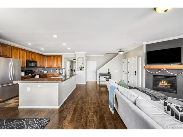 a living room with stainless steel appliances furniture and a flat screen tv