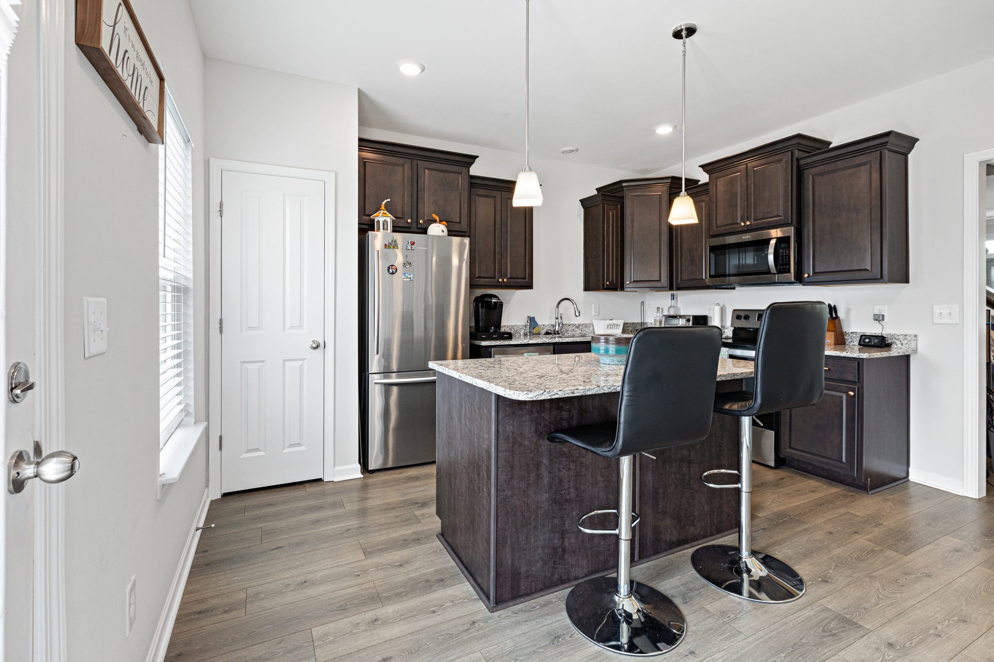 204 Kinsale Drive Spring Hill, TN 37174 - Photo 10 of 31 a kitchen with stainless steel appliances granite countertop a refrigerator a stove a sink dishwasher and a dining table with wooden floor