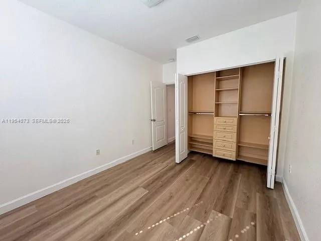 a view of a room with wooden floor and white doors