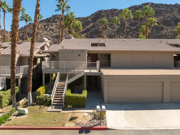 a front view of a house with a chairs and table