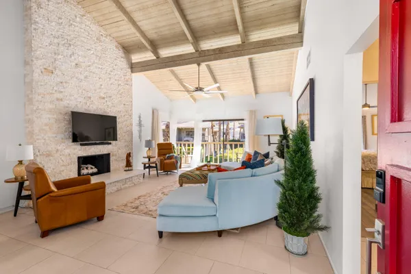 a living room with furniture a flat screen tv and a fireplace
