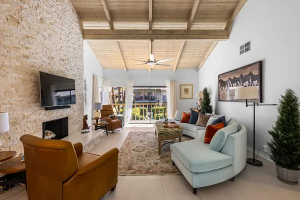 a living room with furniture a flat screen tv and a fireplace