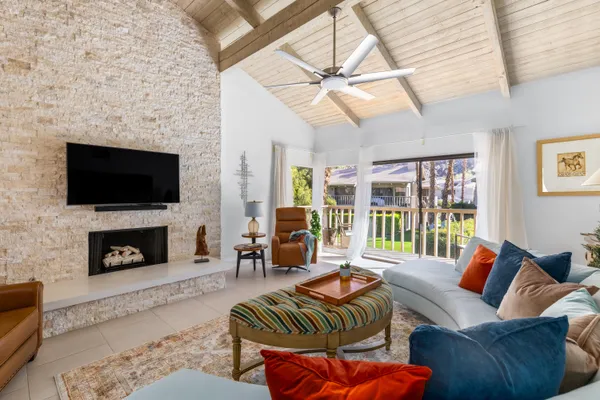 a view of a dining room with furniture a potted plant and a chandelier