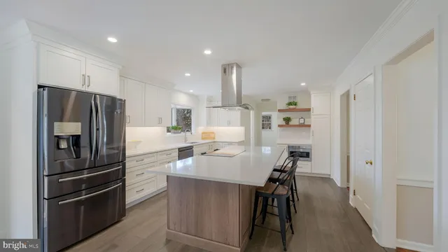 a kitchen with refrigerator a sink and chairs