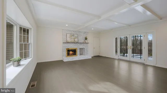 a view of an empty room with glass door and wooden floor