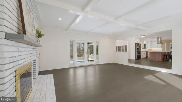 a view of a livingroom with wooden floor and a fireplace