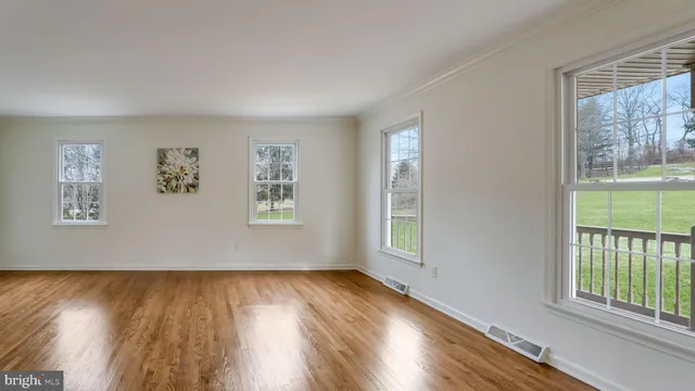 a view of a big room with wooden floor and windows
