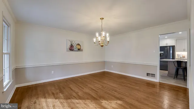 a view of a room with wooden floor and chandelier