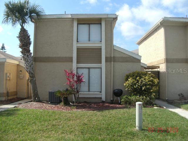 1030 Abada Court Northeast, Unit 110 Palm Bay, FL 32905 - Photo 1 of 10 a front view of a house having yard