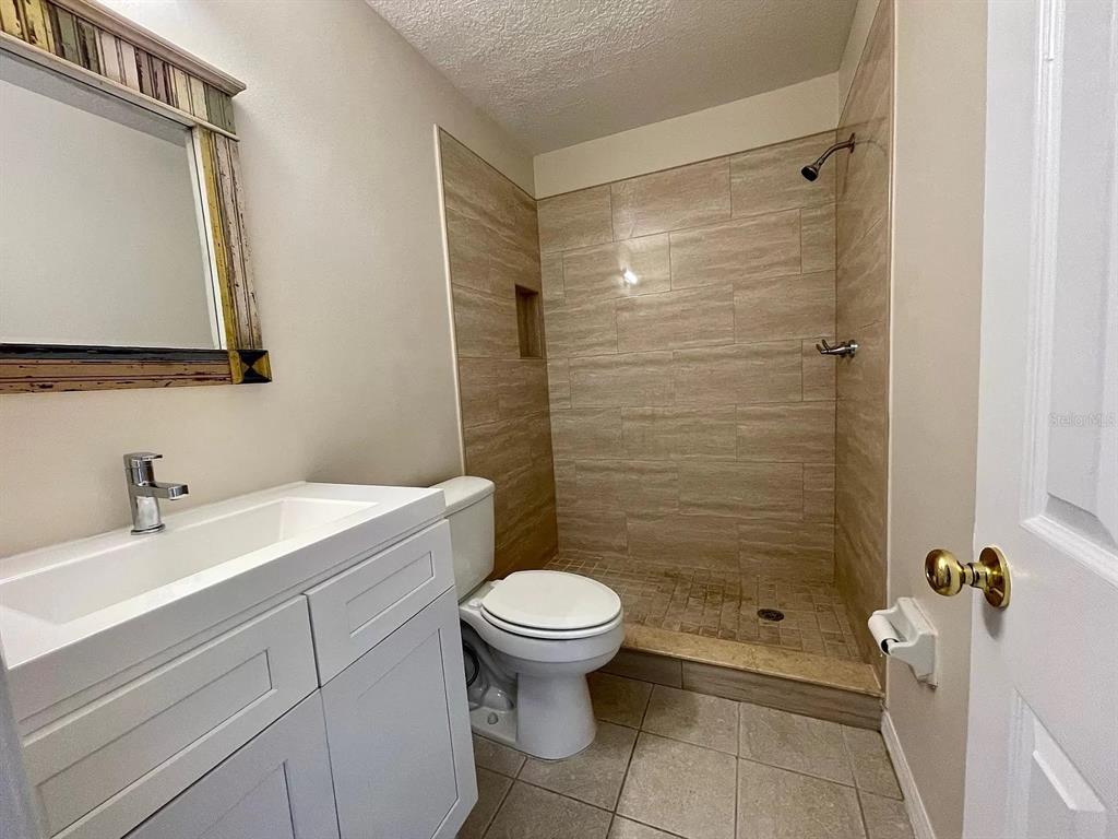 1030 Abada Court Northeast, Unit 110 Palm Bay, FL 32905 - Photo 8 of 10 a bathroom with a sink a toilet and shower