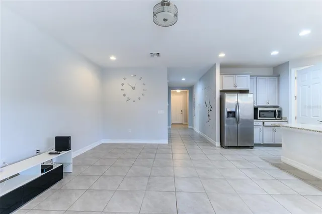 a kitchen with stainless steel appliances kitchen island granite countertop a refrigerator and a stove top oven