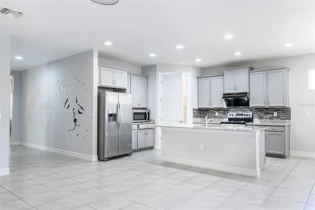 a kitchen with kitchen island granite countertop stainless steel appliances and cabinets
