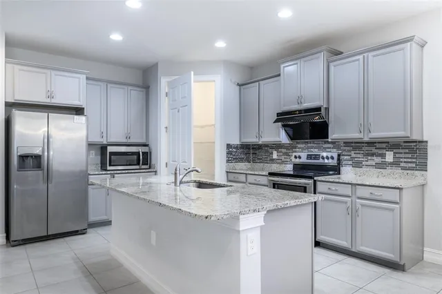 a kitchen with stainless steel appliances granite countertop a refrigerator sink and cabinets