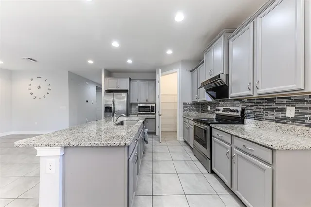 a kitchen with a sink stove and cabinets