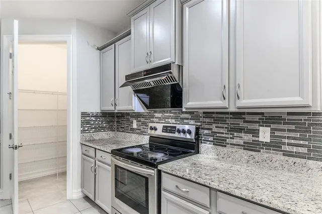 a large kitchen with stainless steel appliances granite countertop a stove and a sink