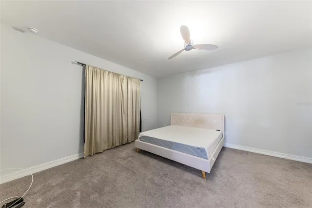 a spacious bedroom with a bed and a window