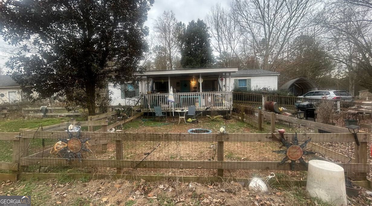 a view of a patio with table and chairs potted plants and large tree
