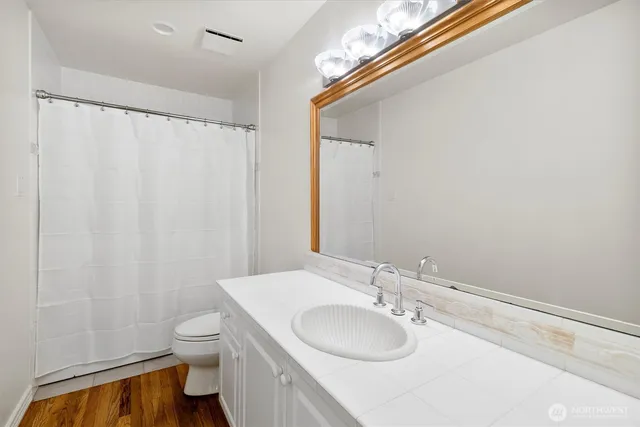 a bathroom with a sink vanity mirror and toilet