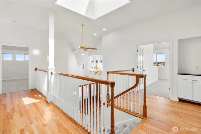 a view of a hallway with wooden floor and staircase