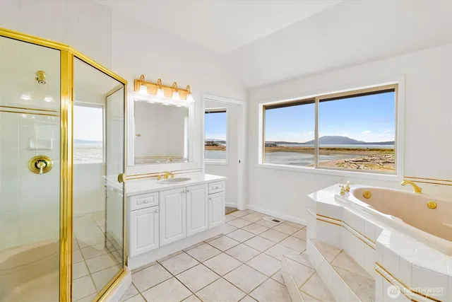 a spacious bathroom with a granite countertop sink mirror and bathtub