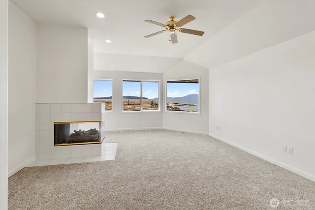 a living room with a fireplace furniture a rug and a window