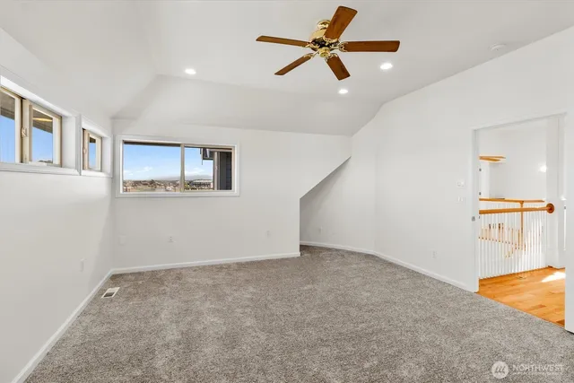a view of a big room with wooden floor and a ceiling fan