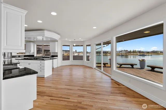 a large white kitchen with a large window and stainless steel appliances