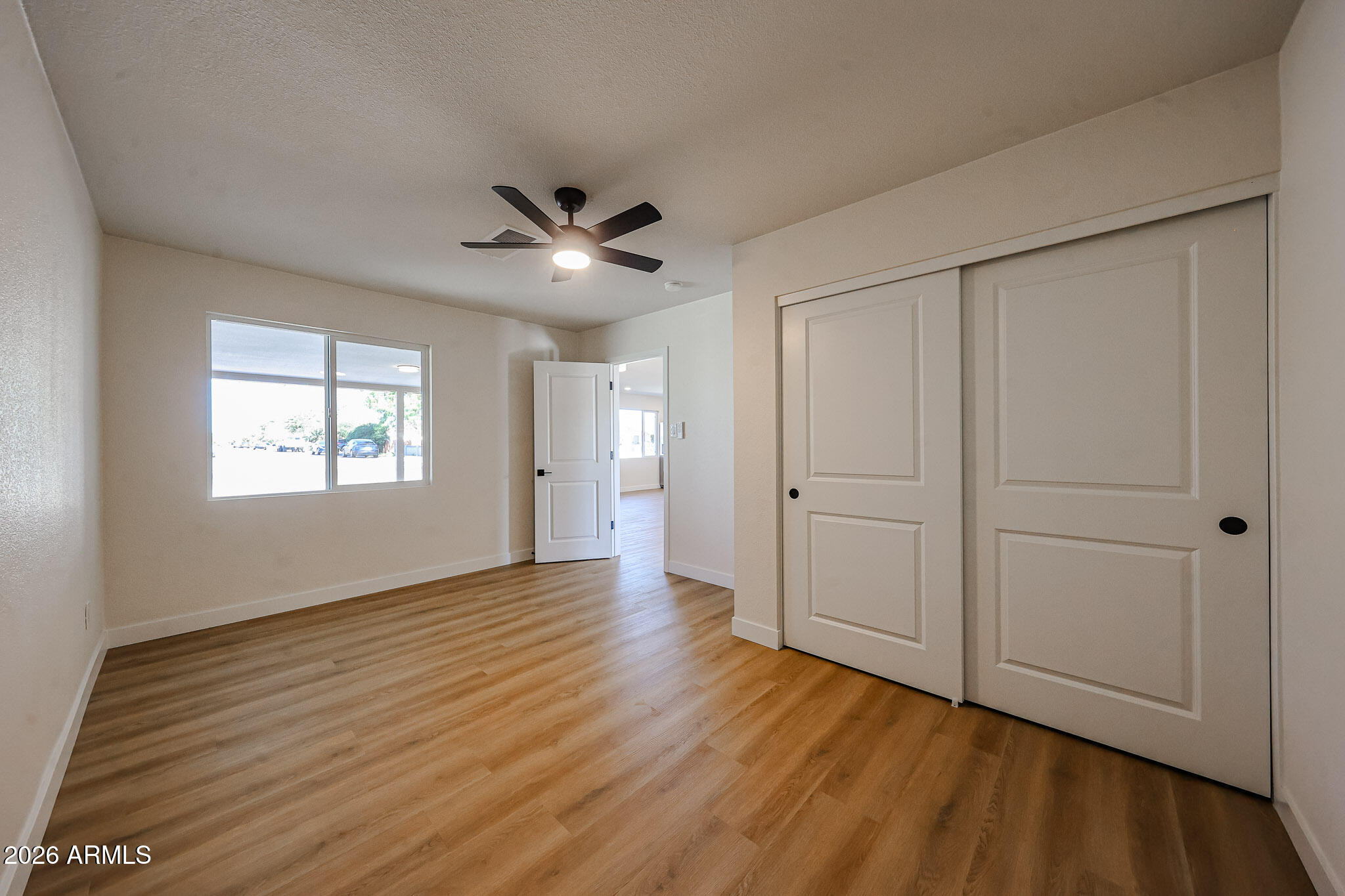3337 West Ocotillo Road Phoenix, AZ 85017 - Photo 12 of 30 a view of an empty room with wooden floor and a window