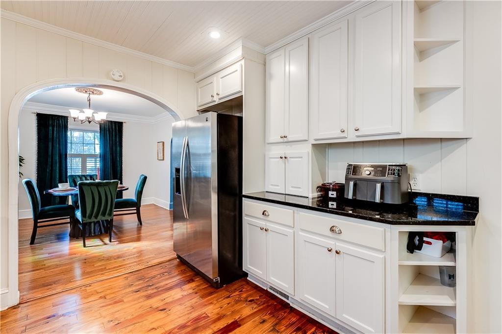 2083 West Rugby Avenue College Park, GA 30337 - Photo 12 of 49 a kitchen with granite countertop a refrigerator a stove a sink and white cabinets with wooden floor