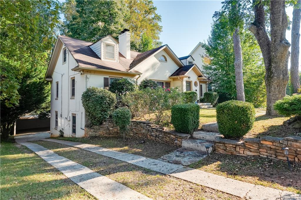 2083 West Rugby Avenue College Park, GA 30337 - Photo 2 of 49 a view of a white house next to a yard with plants and large trees