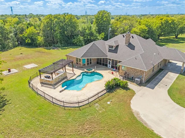 an aerial view of a house with swimming pool garden and outdoor seating