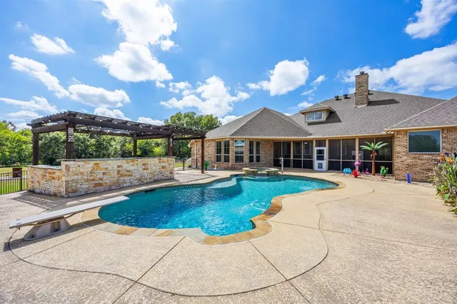 a view of a house with swimming pool and sitting area