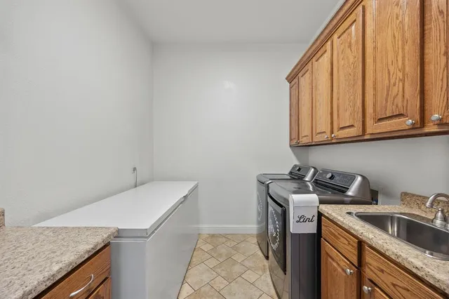 a utility room with sink dryer and washer