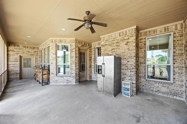 a view of a hallway with a ceiling fan and windows