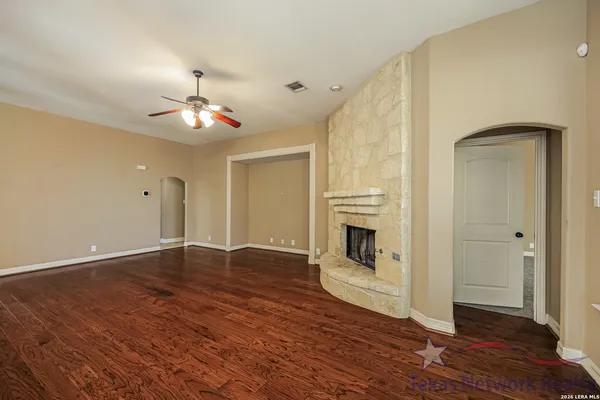 a view of a livingroom with wooden floor a fireplace and window