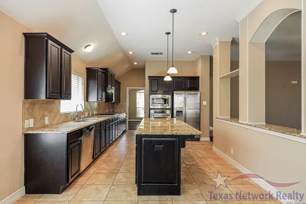 a large kitchen with a large counter top appliances and cabinets