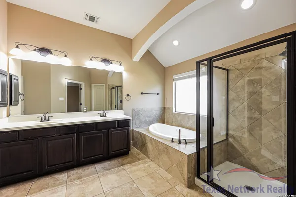 a spacious bathroom with a double vanity sink toilet and shower