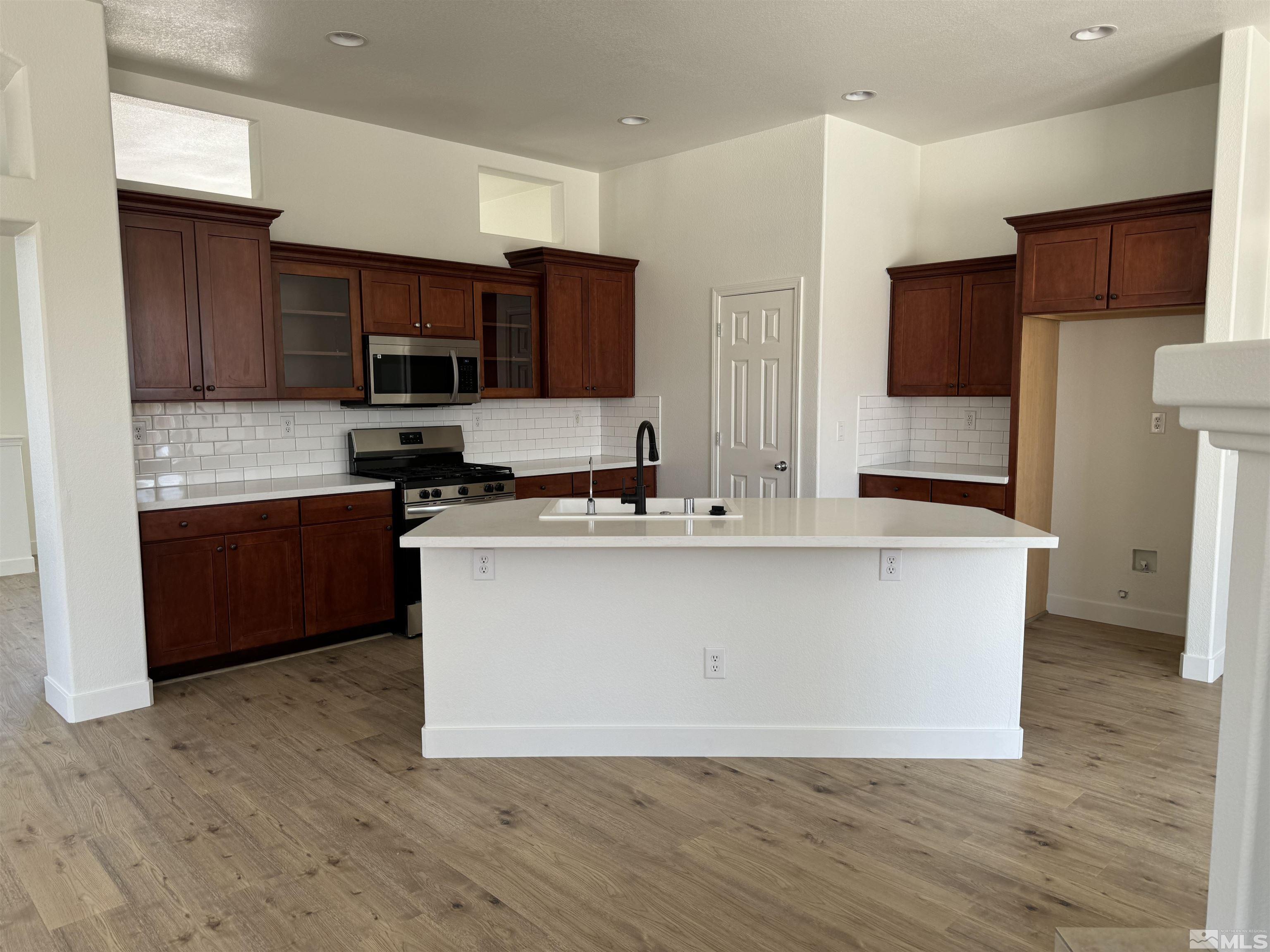 405 Sapphire Way Fallon, NV 89406 - Photo 6 of 30 a living room with stainless steel appliances kitchen island granite countertop a stove a sink and a refrigerator