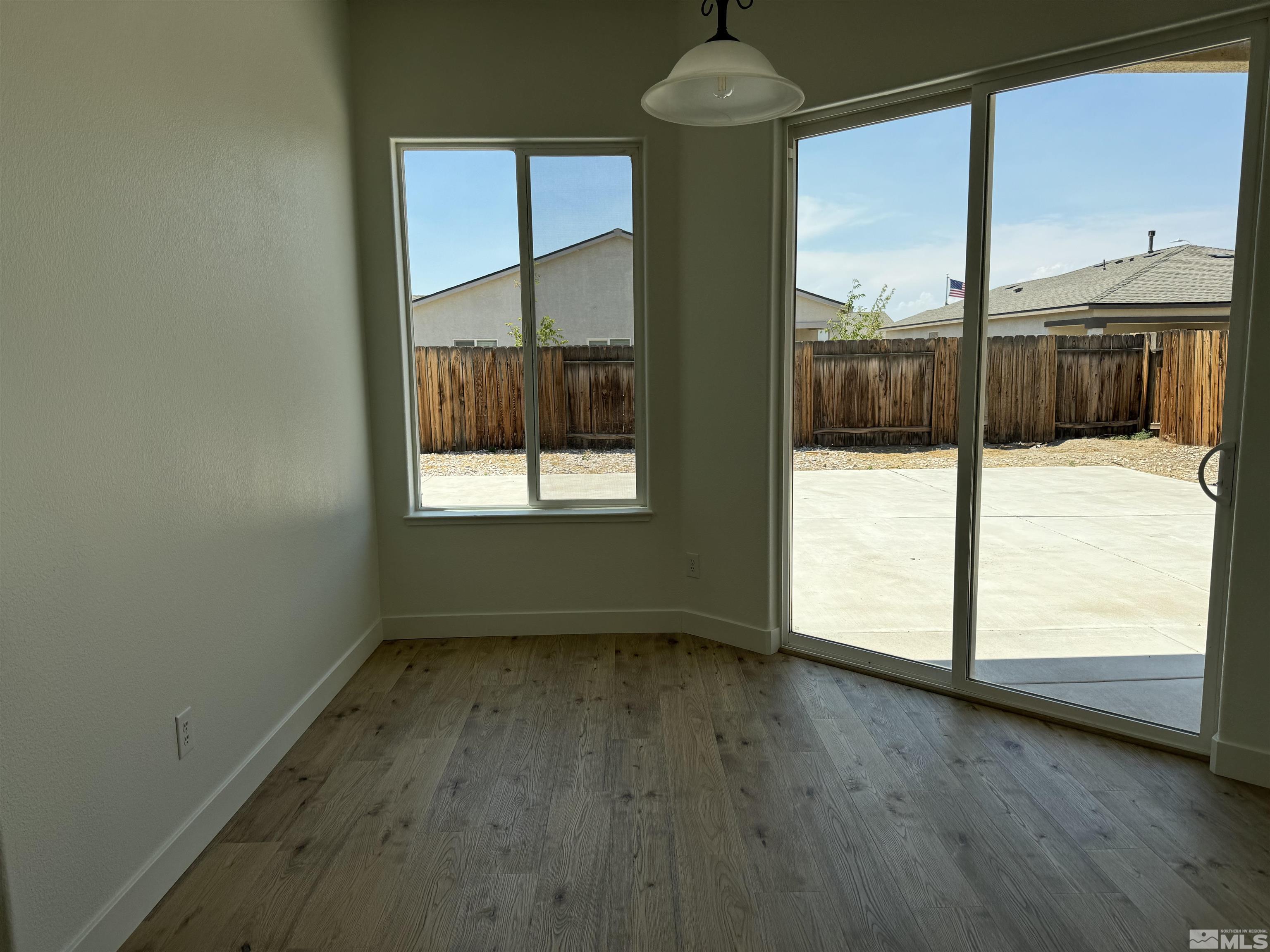 405 Sapphire Way Fallon, NV 89406 - Photo 7 of 30 an empty room with wooden floor and windows