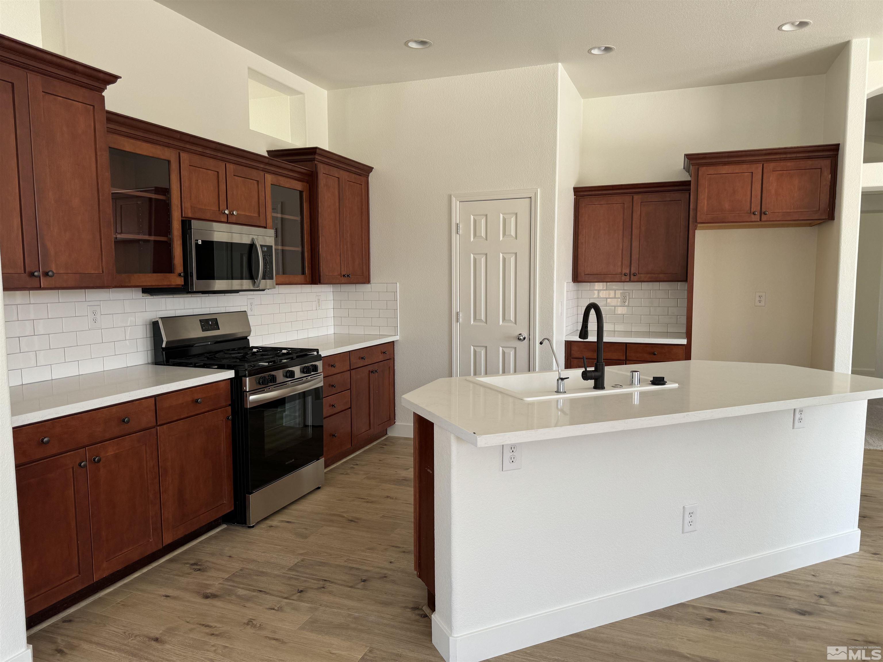405 Sapphire Way Fallon, NV 89406 - Photo 8 of 30 a kitchen with stainless steel appliances a sink stove top oven and refrigerator