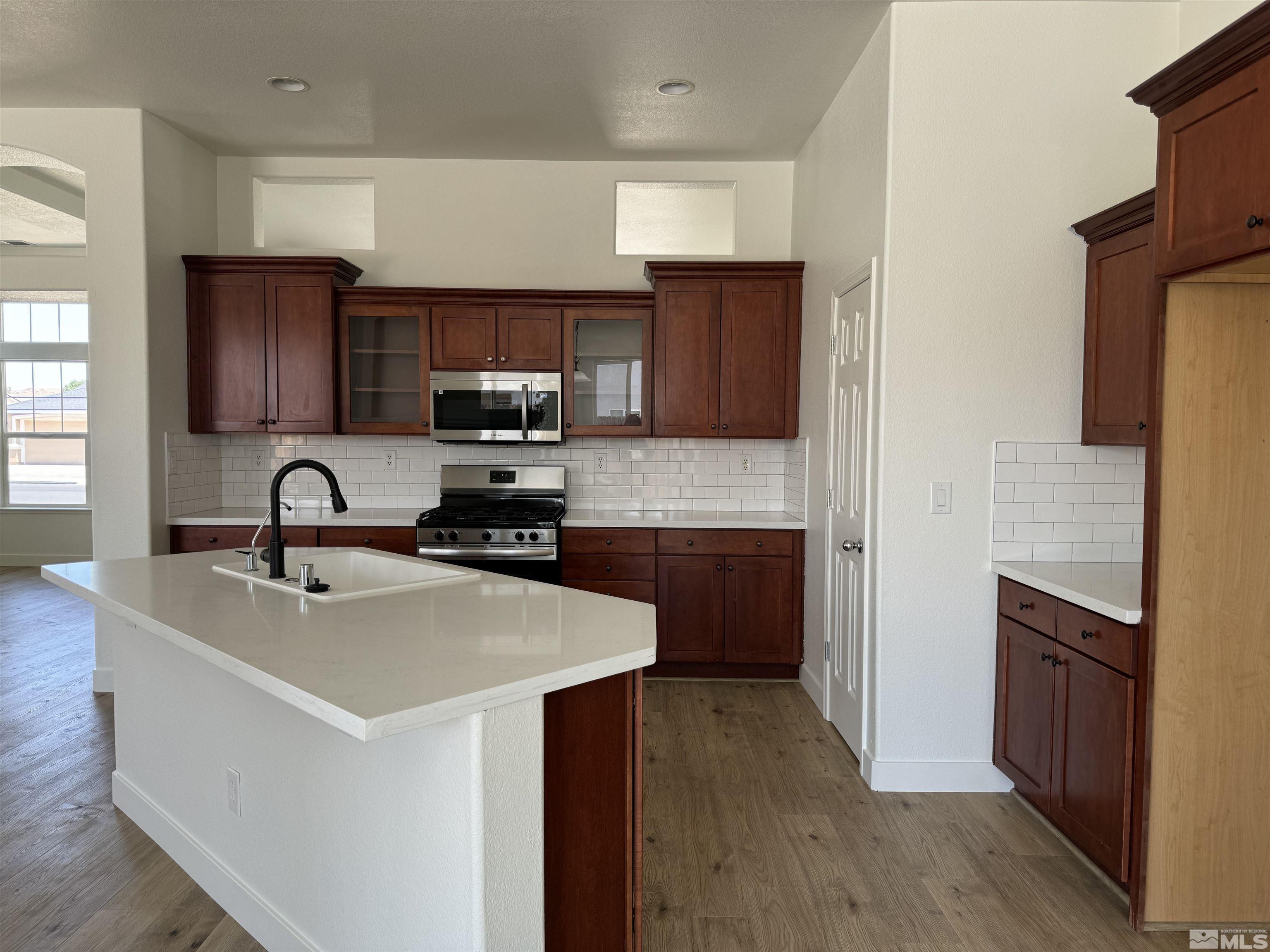 405 Sapphire Way Fallon, NV 89406 - Photo 10 of 30 a kitchen with granite countertop a sink stove and refrigerator