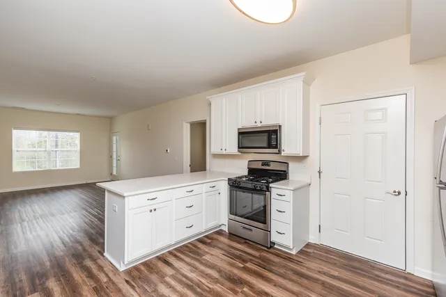a kitchen with stainless steel appliances a stove top oven and a refrigerator