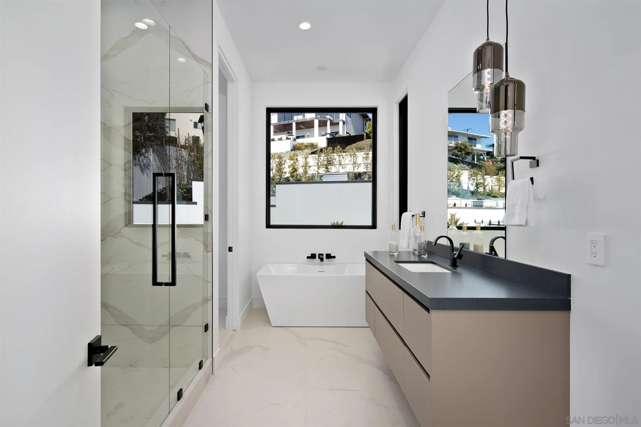 926 La Jolla Rancho Road La Jolla, CA 92037 - Photo 38 of 54 a en suite bathroom with a double vanity sink a mirror and a bathtub