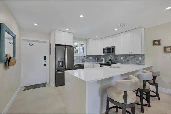 a kitchen with granite countertop white cabinets and stainless steel appliances