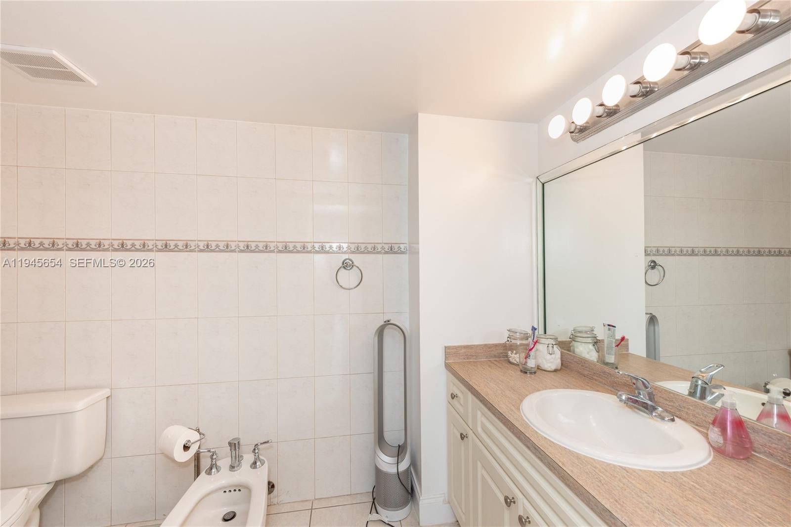 2400 Southwest 3rd Avenue, Unit 703 Miami, FL 33129 - Photo 23 of 29 a bathroom with a granite countertop sink a toilet and shower
