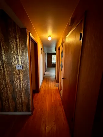 a view of a hallway with wooden floor