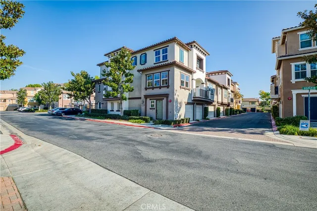 a view of a white house with large windows and a yard