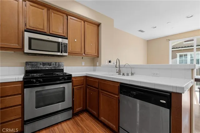a kitchen with stainless steel appliances granite countertop a sink stove and microwave