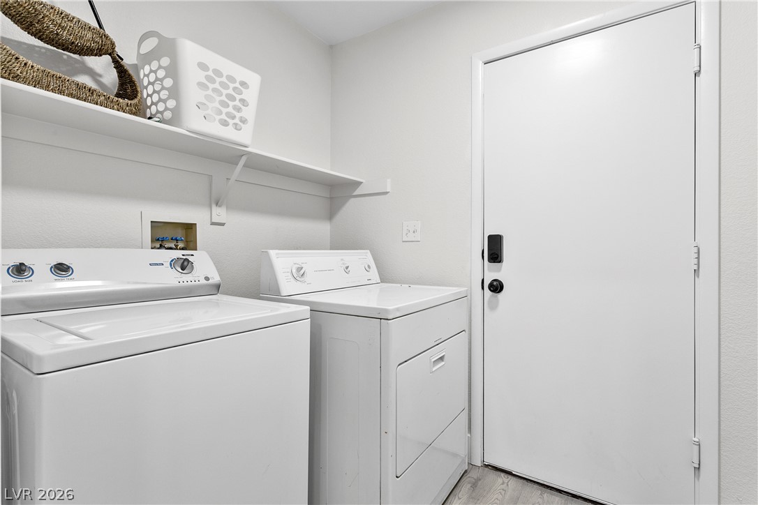 101 Beaver Ridge Avenue North Las Vegas, NV 89031 - Photo 41 of 42 A dedicated utility space with contemporary laundry appliances and practical shelving.